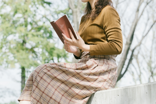 日向で本を読む女性